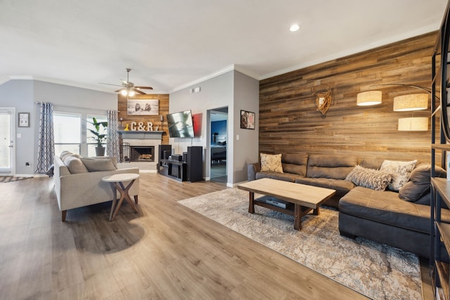 201 E St, Josephine, TX 75173 - living room featuring wooden walls, an accent wall, crown molding, wood finished floors, and ceiling fan