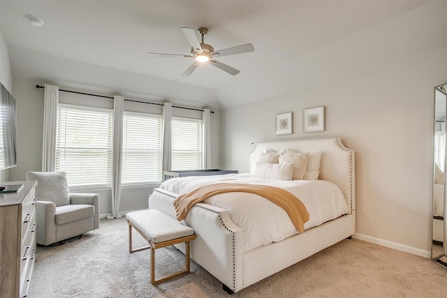 bedroom with multiple windows, light colored carpet, and baseboards