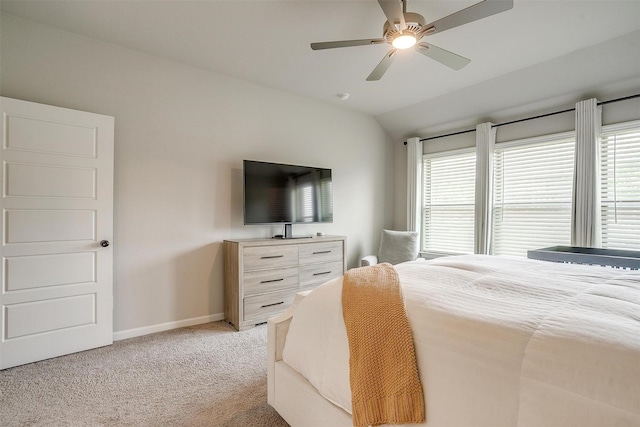 bedroom featuring light colored carpet, lofted ceiling, baseboards, and ceiling fan
