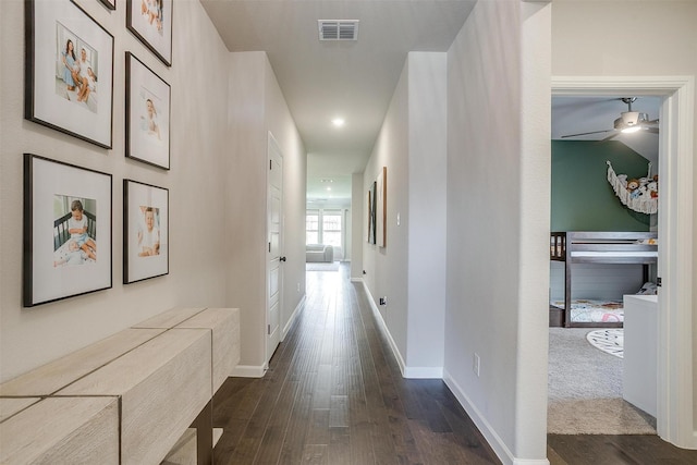 hall with dark wood finished floors, baseboards, and recessed lighting