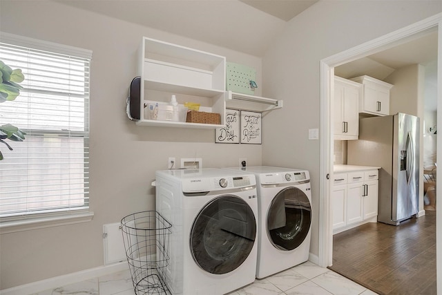 washroom featuring washing machine and clothes dryer, marble finish floors, and baseboards