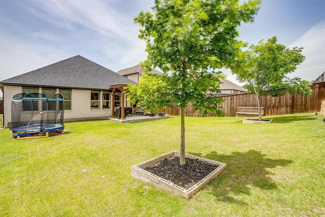 view of yard featuring a trampoline and a patio