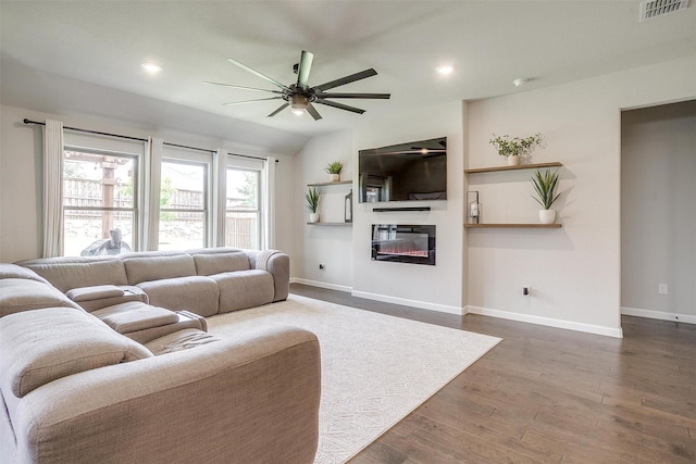 living room featuring ceiling fan, baseboards, a glass covered fireplace, recessed lighting, and dark wood-style floors