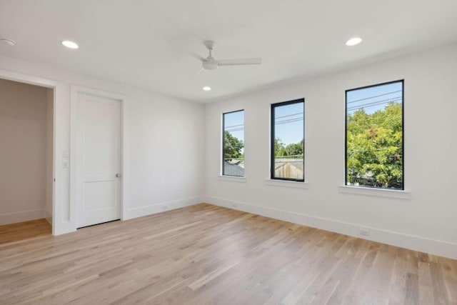 spare room featuring baseboards, light wood-type flooring, ceiling fan, and recessed lighting