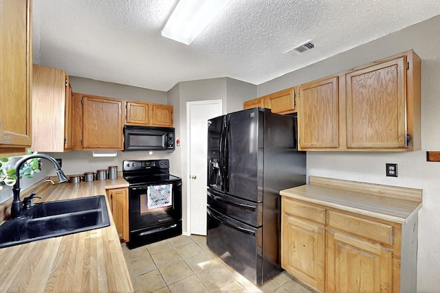 4821 Abbott Ave, Arlington, TX 76018 - kitchen with black appliances, a sink, light countertops, a textured ceiling, and light tile patterned floors