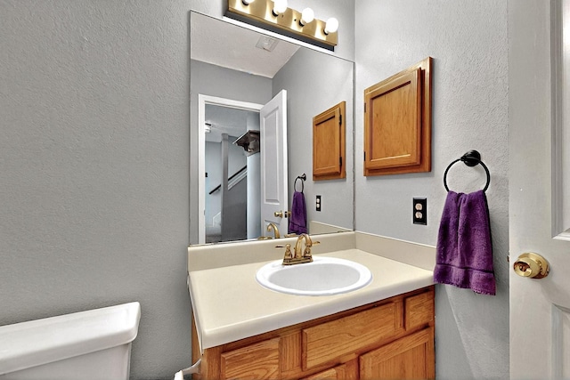 4821 Abbott Ave, Arlington, TX 76018 - half bathroom featuring toilet, a textured wall, and vanity