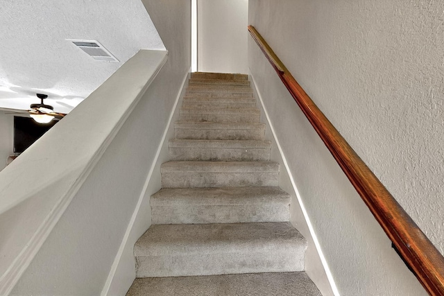 4821 Abbott Ave, Arlington, TX 76018 - stairs featuring a textured ceiling, a ceiling fan, and a textured wall