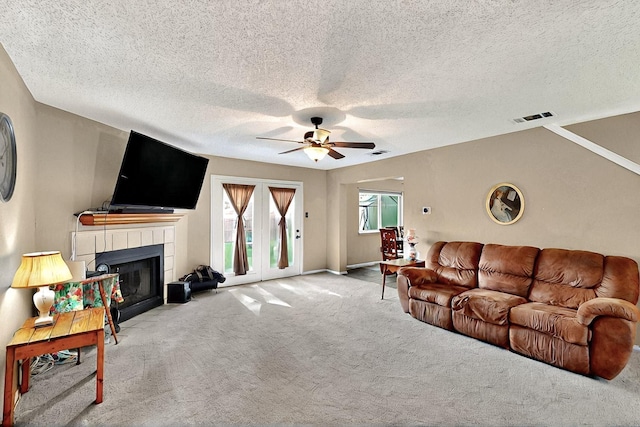 4821 Abbott Ave, Arlington, TX 76018 - carpeted living area featuring a ceiling fan, a tile fireplace, and a textured ceiling