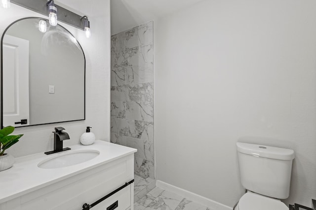 1304 Barnes Dr, Arlington, TX 76013 - bathroom featuring marble look tile flooring, vanity, toilet, and baseboards