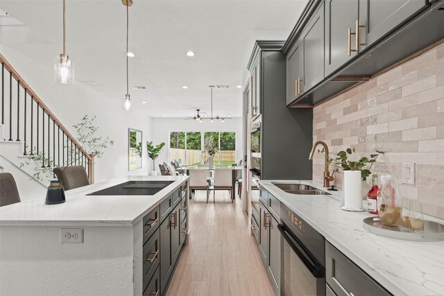 2522 Jeffries St, Dallas, TX 75215 - kitchen featuring a sink, backsplash, black electric cooktop, a center island, and recessed lighting