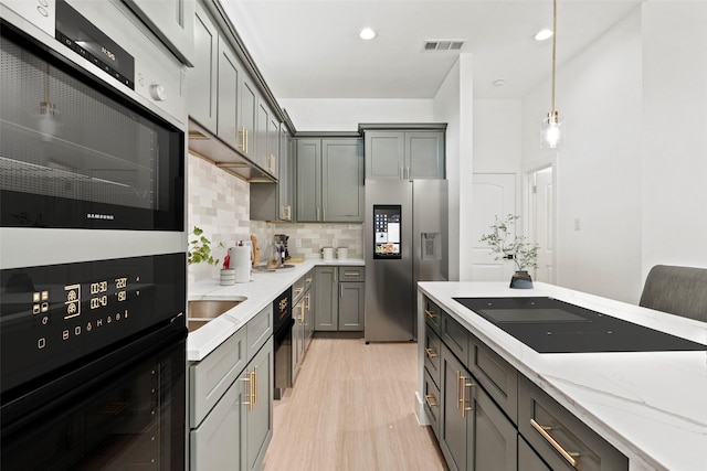 2522 Jeffries St, Dallas, TX 75215 - kitchen featuring stainless steel fridge, light wood-style flooring, tasteful backsplash, double wall oven, and black electric cooktop