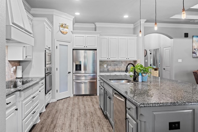 726 County Road 3355, Paradise, TX 76073 - kitchen with stainless steel appliances, a sink, custom range hood, gray cabinets, and arched walkways