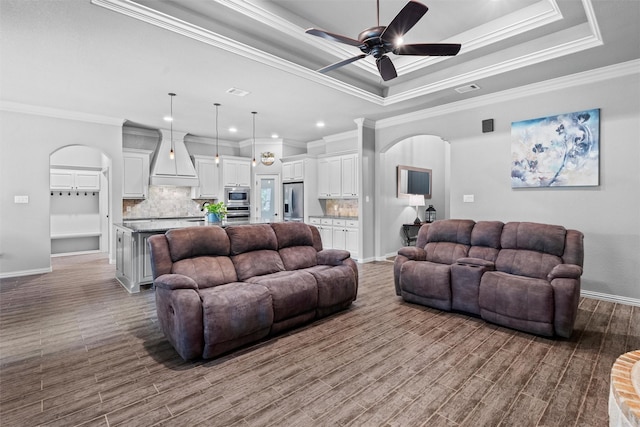 726 County Road 3355, Paradise, TX 76073 - living area featuring arched walkways, a ceiling fan, ornamental molding, a tray ceiling, and baseboards