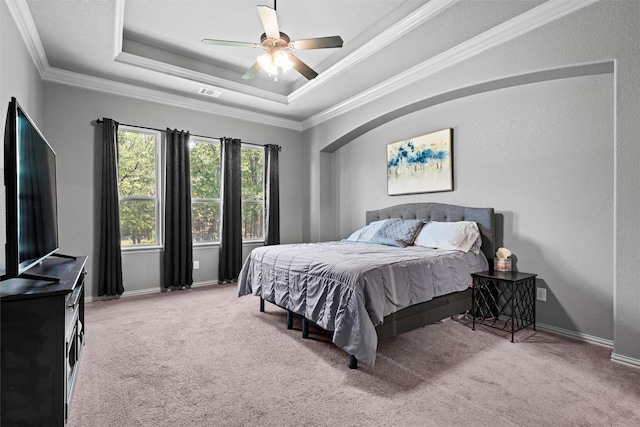 726 County Road 3355, Paradise, TX 76073 - carpeted bedroom featuring ornamental molding, a tray ceiling, a ceiling fan, and arched walkways