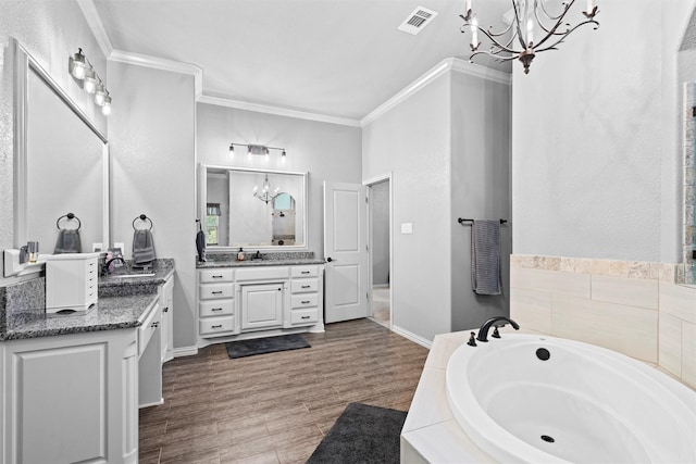 726 County Road 3355, Paradise, TX 76073 - full bathroom with a chandelier, ornamental molding, a garden tub, two vanities, and wood finished floors