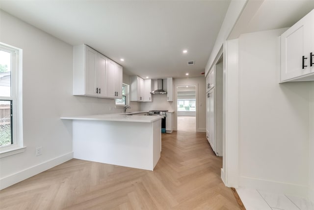 1447 Arizona Ave, Dallas, TX 75216 - kitchen with wall chimney range hood, stainless steel range oven, baseboards, a sink, and light countertops