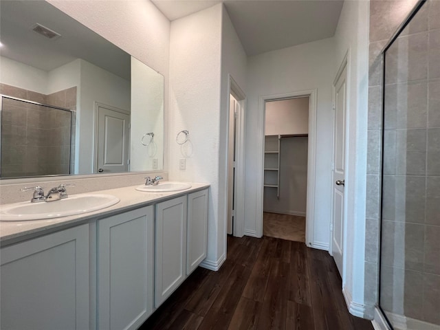 409 Petty Way, Fate, TX 75189 - full bath featuring a shower stall, wood finished floors, a spacious closet, and double vanity