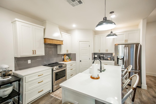 100 E 3rd St, Tolar, TX 76476 - kitchen with stainless steel appliances, custom exhaust hood, backsplash, dark wood-style floors, and light countertops