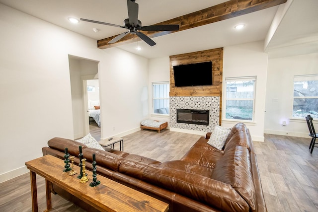 100 E 3rd St, Tolar, TX 76476 - living area featuring beam ceiling, a ceiling fan, baseboards, wood finished floors, and a fireplace