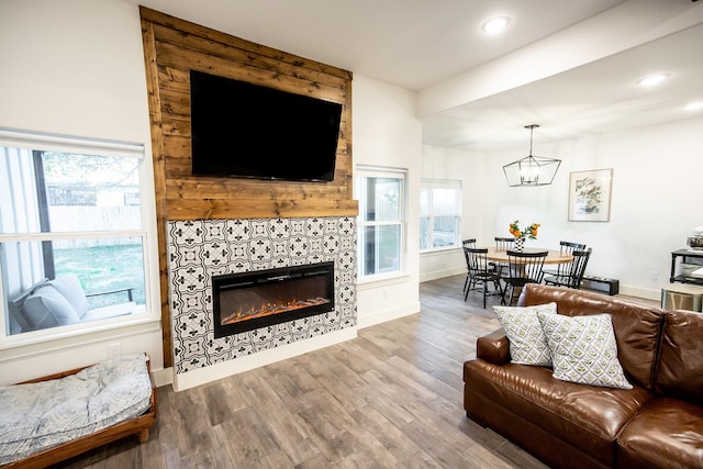 100 E 3rd St, Tolar, TX 76476 - living room featuring wood finished floors, a chandelier, recessed lighting, a tiled fireplace, and plenty of natural light