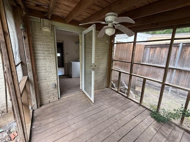 unfurnished sunroom with washer / clothes dryer, beam ceiling, and ceiling fan