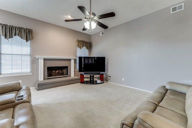 1729 Sheffield Dr, Garland, TX 75040 - carpeted living room featuring a ceiling fan, a fireplace, baseboards, and a textured ceiling