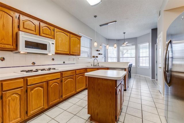 1729 Sheffield Dr, Garland, TX 75040 - kitchen with white appliances, a sink, light countertops, a textured ceiling, and a peninsula