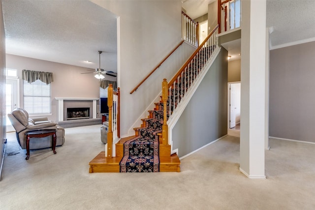 1729 Sheffield Dr, Garland, TX 75040 - staircase featuring carpet floors, a fireplace, ceiling fan, baseboards, and a textured ceiling