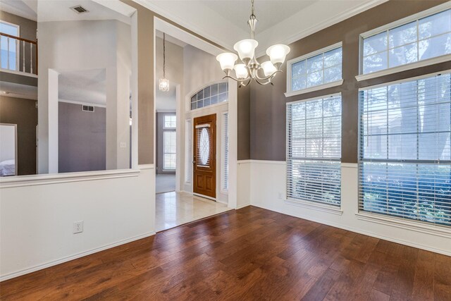 1729 Sheffield Dr, Garland, TX 75040 - entryway featuring a high ceiling, wood finished floors, a chandelier, and a wainscoted wall