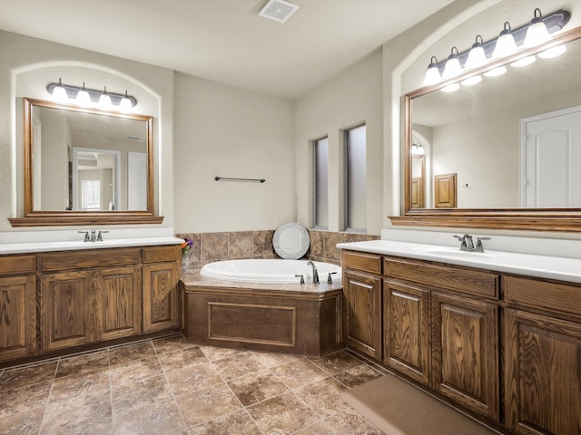 214 Crestbrook Dr, Rockwall, TX 75087 - bathroom with a garden tub, two vanities, and stone finish flooring