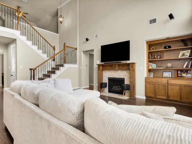 214 Crestbrook Dr, Rockwall, TX 75087 - living room with a towering ceiling, dark wood finished floors, stairway, a fireplace, and baseboards