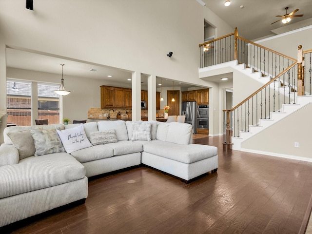 214 Crestbrook Dr, Rockwall, TX 75087 - living area with dark wood-style floors, stairs, a ceiling fan, baseboards, and a towering ceiling