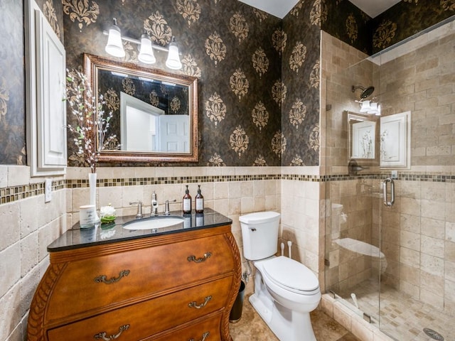 5040 Loma Alta Dr, Frisco, TX 75034 - bathroom with a shower stall, toilet, a wainscoted wall, tile walls, and vanity