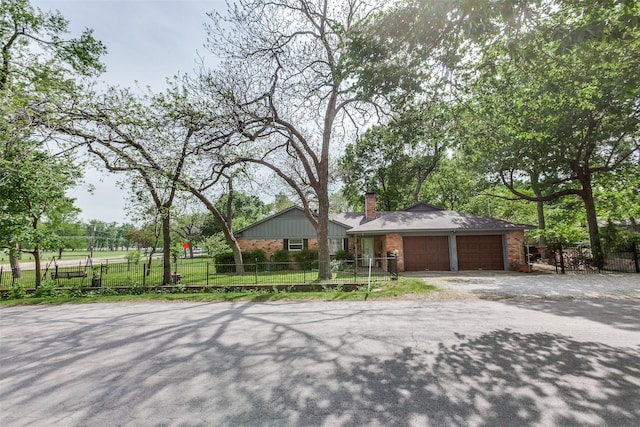 9551 E Lake Highlands Dr, Dallas, TX 75218 - view of front of house featuring brick siding, an attached garage, a chimney, and asphalt driveway