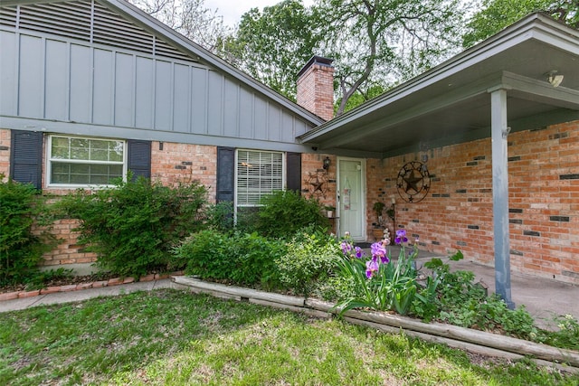 9551 E Lake Highlands Dr, Dallas, TX 75218 - entrance to property with board and batten siding, a chimney, and brick siding