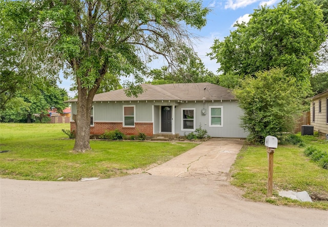view of front of home with concrete driveway, brick siding, central AC unit, a front lawn, and a shingled roof