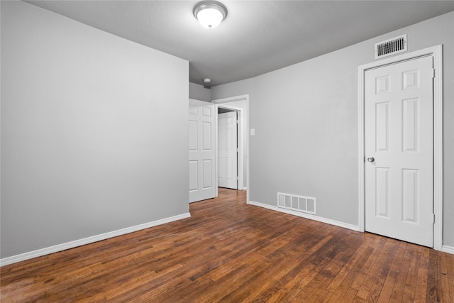 unfurnished bedroom with wood finished floors and baseboards