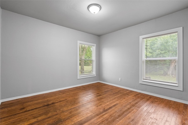 empty room featuring wood-type flooring and baseboards