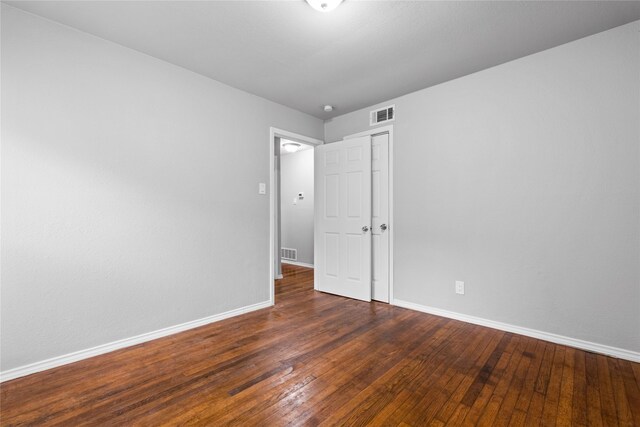 spare room featuring baseboards and hardwood / wood-style floors