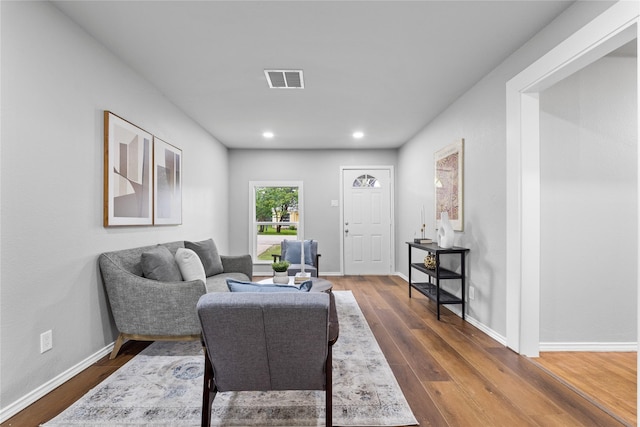 sitting room featuring dark wood-type flooring, baseboards, and recessed lighting