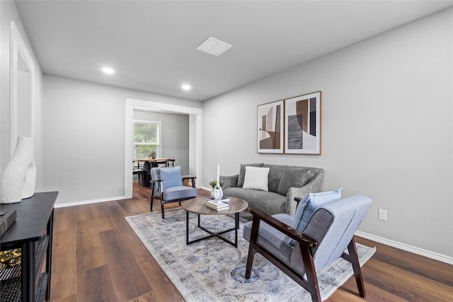 living room featuring dark wood-type flooring, recessed lighting, and baseboards