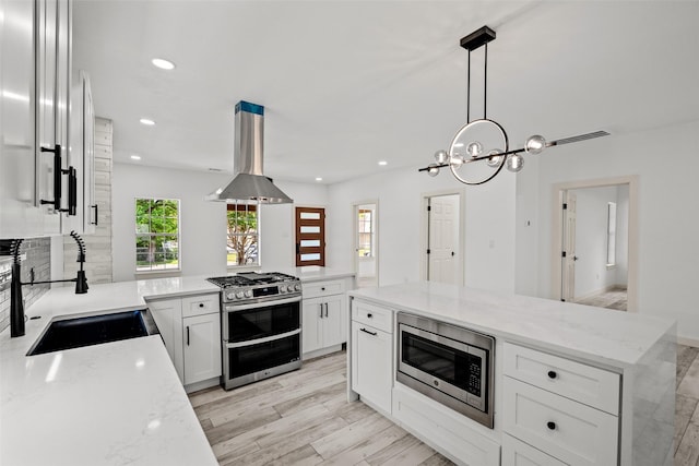807 S Edgefield Ave, Dallas, TX 75208 - kitchen featuring appliances with stainless steel finishes, island range hood, a sink, recessed lighting, and white cabinets