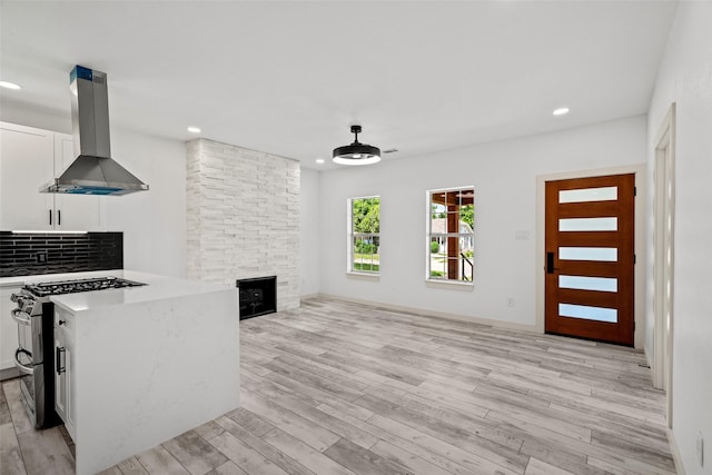 807 S Edgefield Ave, Dallas, TX 75208 - unfurnished living room featuring light wood finished floors, recessed lighting, and a stone fireplace