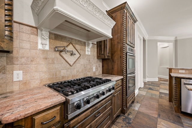 113 Welford Ln, Southlake, TX 76092 - kitchen featuring appliances with stainless steel finishes, backsplash, crown molding, light stone counters, and stone tile flooring