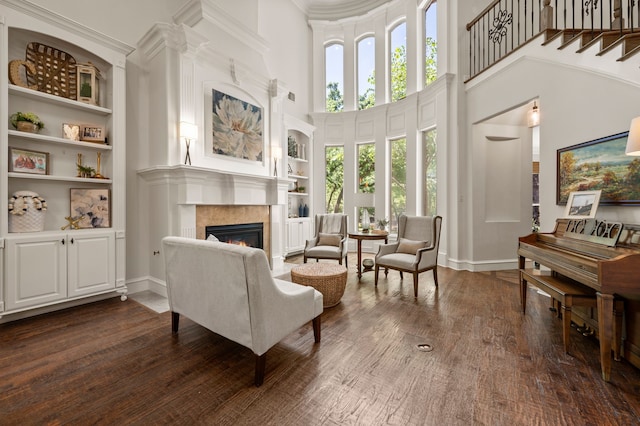 113 Welford Ln, Southlake, TX 76092 - living area with a towering ceiling, built in features, a warm lit fireplace, dark wood finished floors, and baseboards