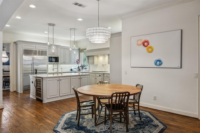 6005 Arboretum Dr, Frisco, TX 75034 - dining space with beverage cooler, crown molding, baseboards, recessed lighting, and dark wood finished floors
