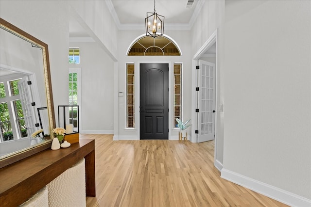1740 Highland Meadows Dr, Prosper, TX 75078 - entrance foyer with a chandelier, light wood-style floors, a towering ceiling, and ornamental molding