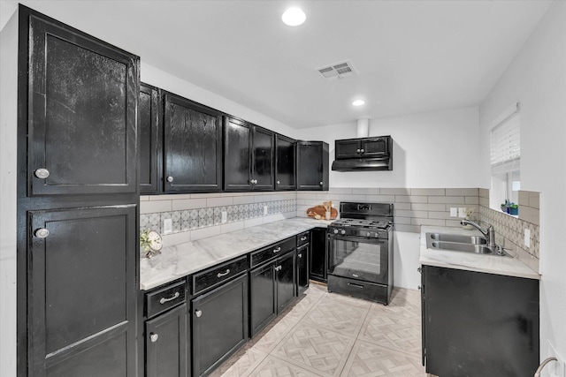2305 Joey Dr, Waco, TX 76711 - kitchen with black gas range, a sink, dark cabinetry, backsplash, and recessed lighting