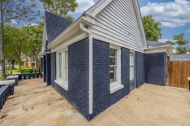 2741 Ivandell Ave, Dallas, TX 75211 - view of side of property featuring a patio, brick siding, a shingled roof, and fence