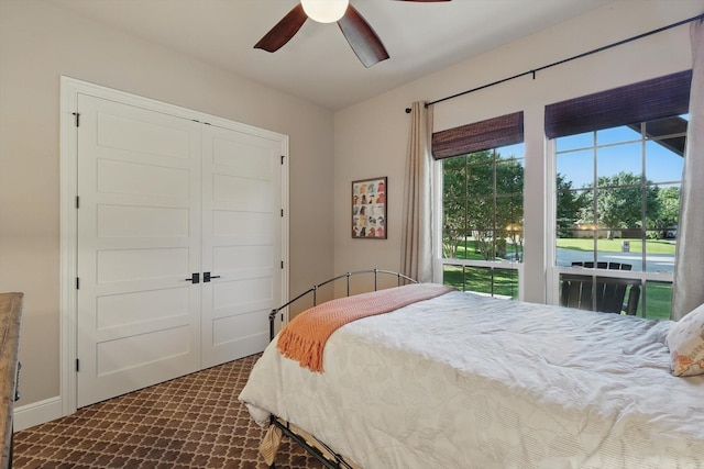bedroom featuring dark carpet, a closet, and a ceiling fan